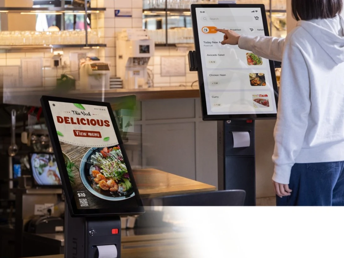 Dos kioscos de autoservicio iMin Crane 1 en un restaurante, uno de ellos con una clienta pidiendo en la pantalla